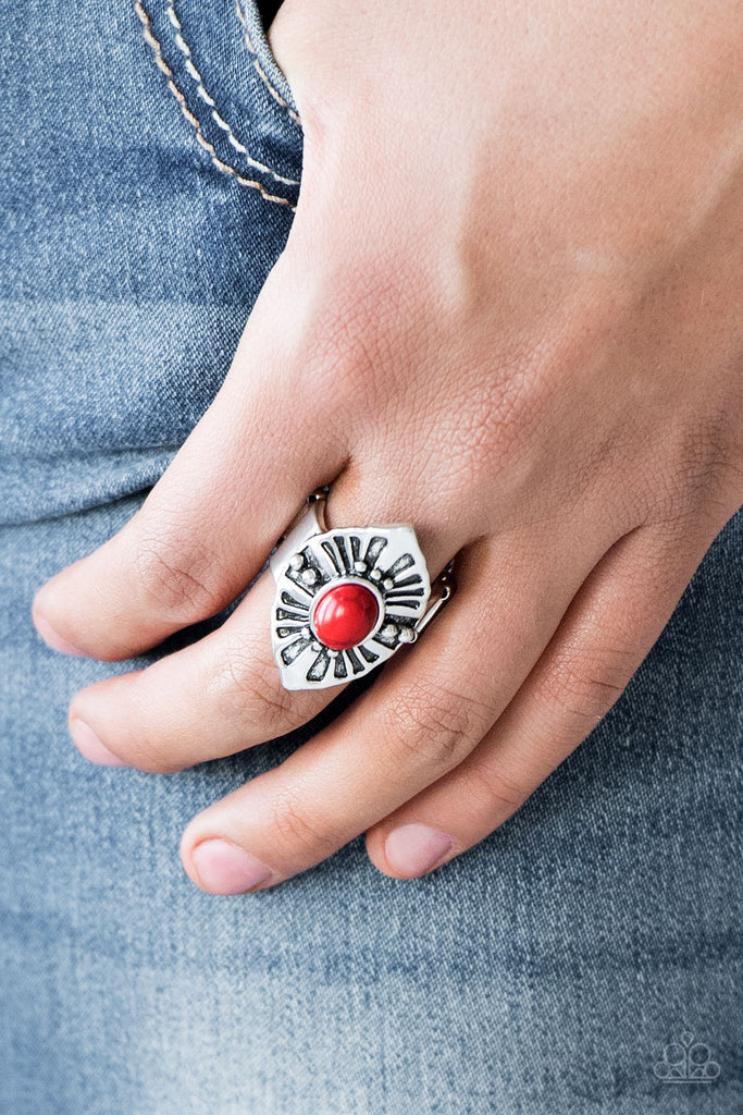 A fiery red stone bead is pressed into the center of an angular silver frame radiating with studded and antiqued textures. Features a stretchy band for a flexible fit.  Sold as one individual ring.