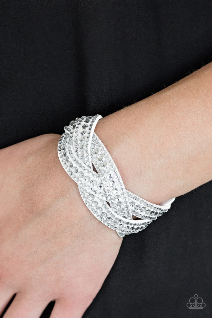 Varying in size, glassy white rhinestones are encrusted along interwoven white suede bands, creating blinding shimmer across the wrist. Features an adjustable snap closure.  Sold as one individual bracelet.