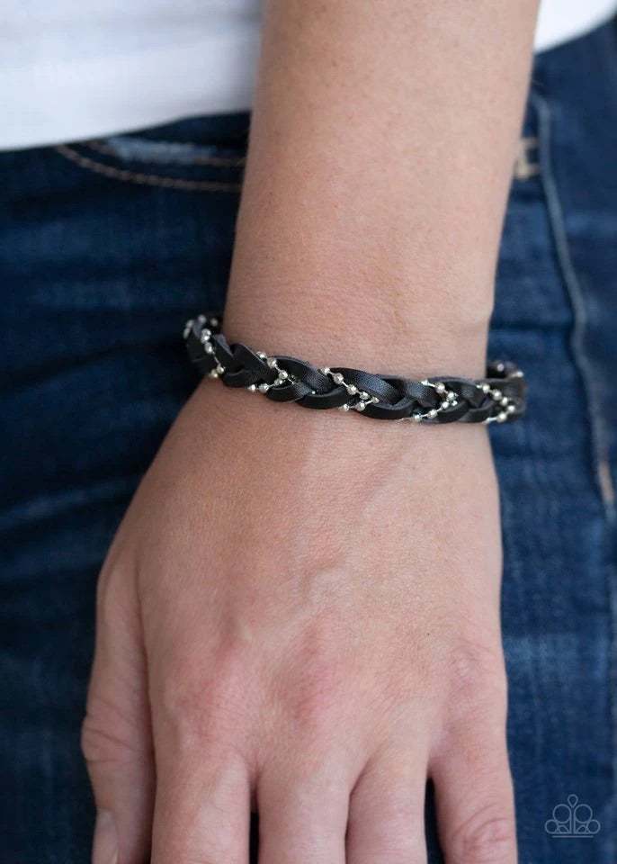 Strands of dainty silver ball chain weaves with black leather laces across the wrist, creating a rustic braid. Features an adjustable sliding knot closure.  Sold as one individual bracelet.