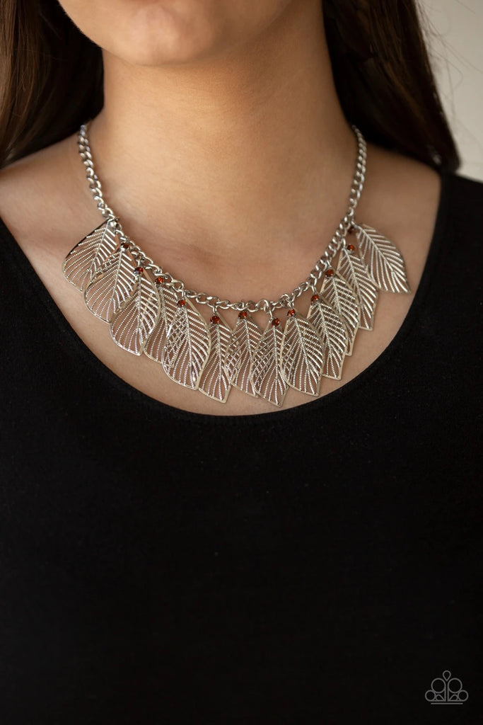 Dainty topaz rhinestones and leafy silver feathers swing from a thick silver chain, creating a whimsical fringe below the collar. Features an adjustable clasp closure.  Sold as one individual necklace. Includes one pair of matching earrings.  