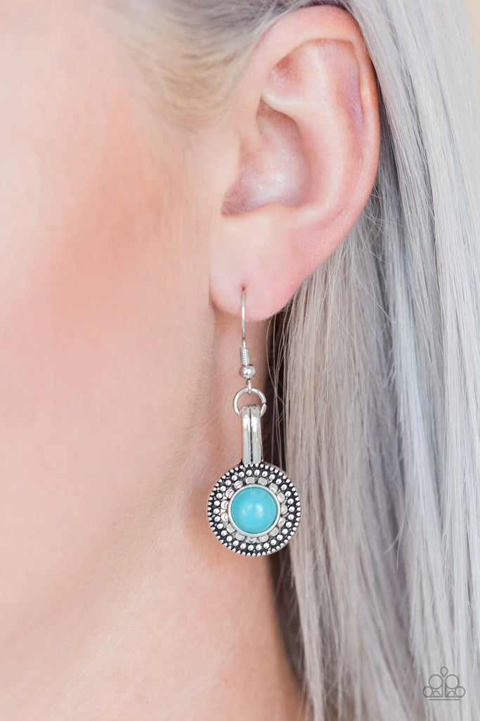 Attached to an antiqued silver fitting, a refreshing turquoise stone is pressed into the center of studded silver frame for a seasonal look. Earring attaches to a standard fishhook fitting.  Sold as one pair of earrings.  