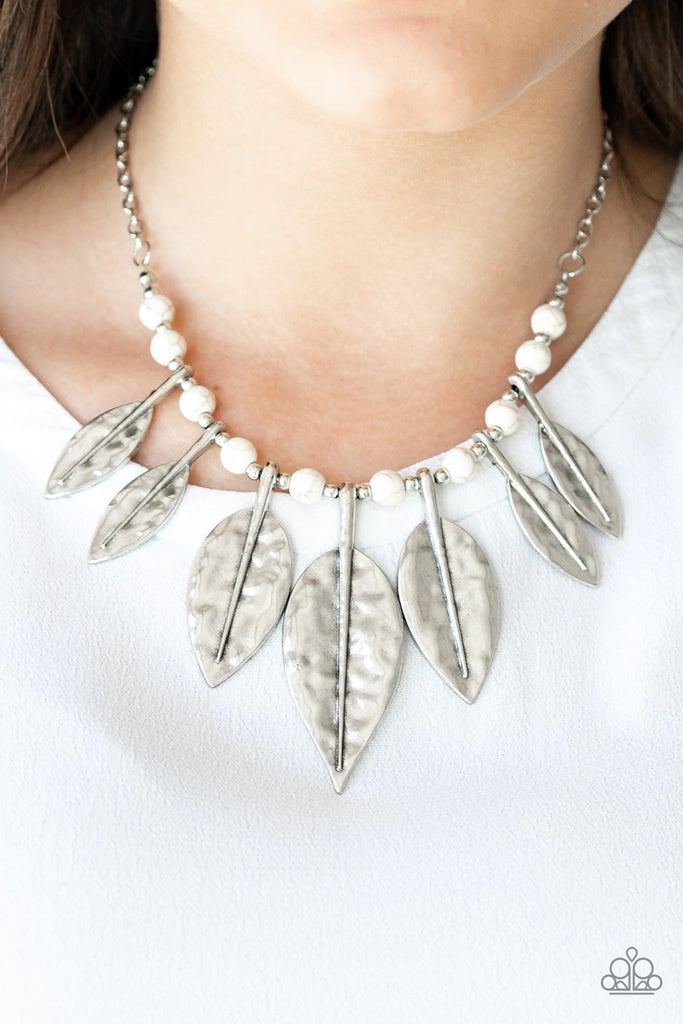 Featuring lifelike detail, hammered silver leaf frames are threaded along an invisible wire below the collar. Infused with dainty silver and refreshing white stone beads, the leafy frames gradually increase in size for an artisan inspired finish. Features an adjustable clasp closure.  Sold as one individual necklace. Includes one pair of matching earrings.