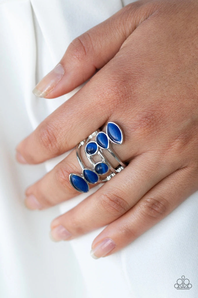 Featuring round, teardrop, and marquise shapes, two frames of glowing blue cat's eye stones stack across a layered silver band for an all around radiance. Features a stretchy band for a flexible fit.  Sold as one individual ring.