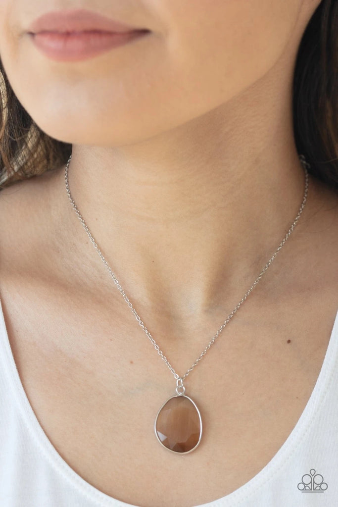 Featuring an opalescent finish, a flat faceted brown gem is pressed into a sleek silver frame at the bottom of a dainty silver chain for a refined flair. Features an adjustable clasp closure.  Sold as one individual necklace. Includes one pair of matching earrings.