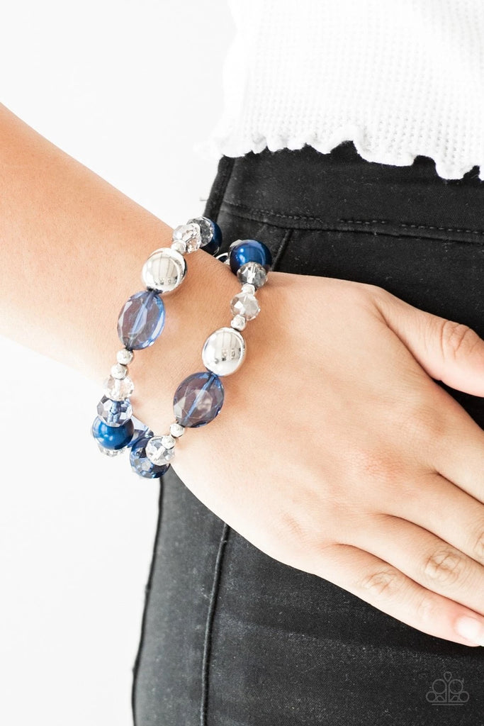 An array of blue pearls, shiny silver beads, and metallic crystal-like beads are threaded along stretchy bands around the wrist for a refined look.  Sold as one set of two bracelets.