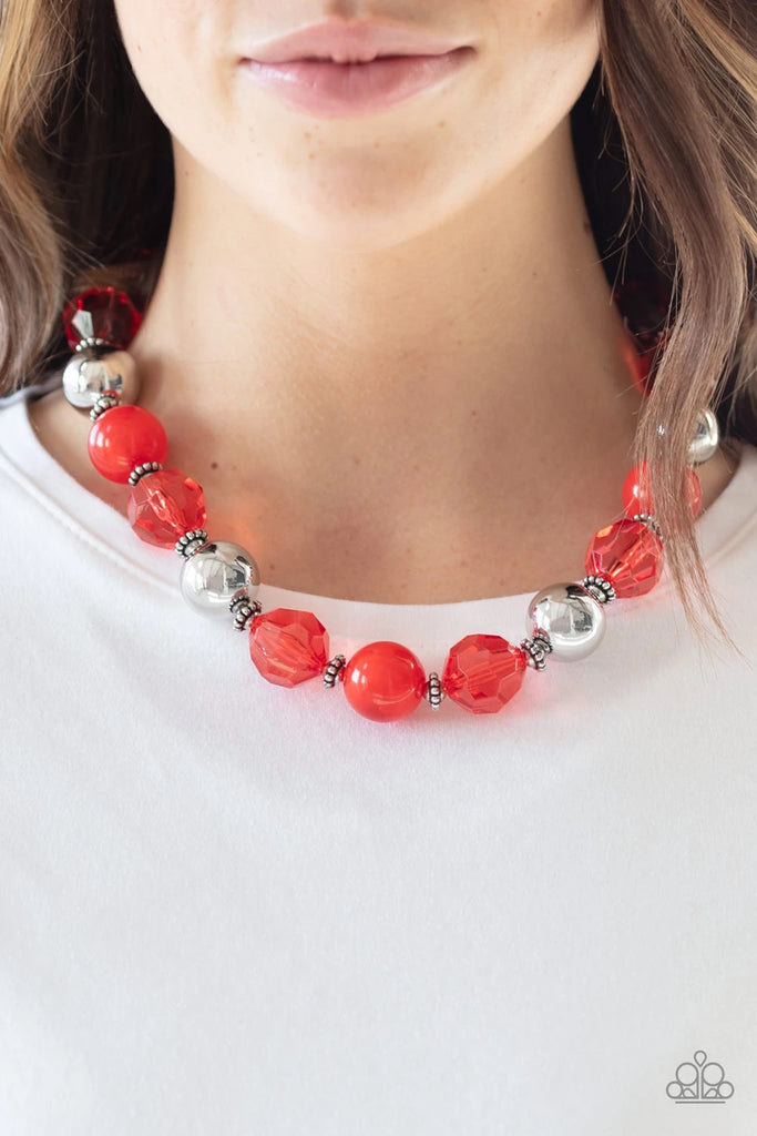 Infused with dainty silver accents, exaggerated display of oversized silver beads, faceted red crystal-like beads, and cloudy red beads are threaded along an invisible wire below the collar for a colorfully statement-making fashion. Features an adjustable clasp closure.  Sold as one individual necklace. Includes one pair of matching earrings.