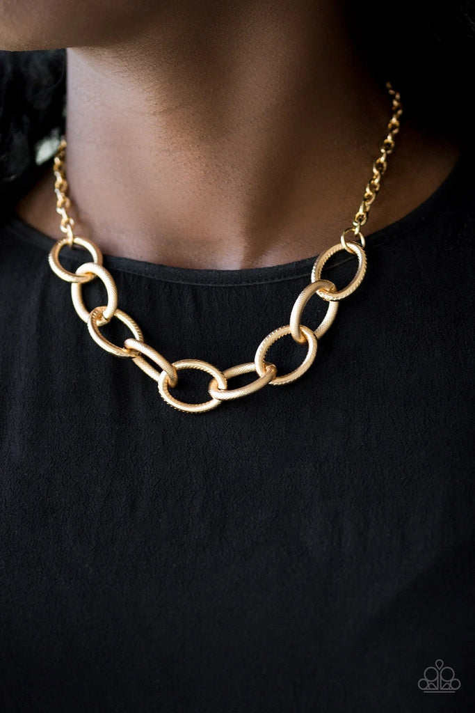 Featuring mismatched textures, bold gold links connect below the collar for a dramatic industrial look. Features an adjustable clasp closure.  Sold as one individual necklace. Includes one pair of matching earrings.  