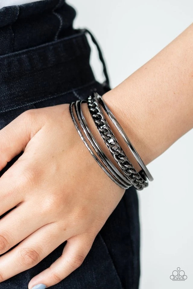 Pairs of smooth and textured gunmetal bangles join an antiqued bangle around the wrist that is decorated in a single strand of gunmetal chain for a gritty finish.  Sold as one set of five bracelets.