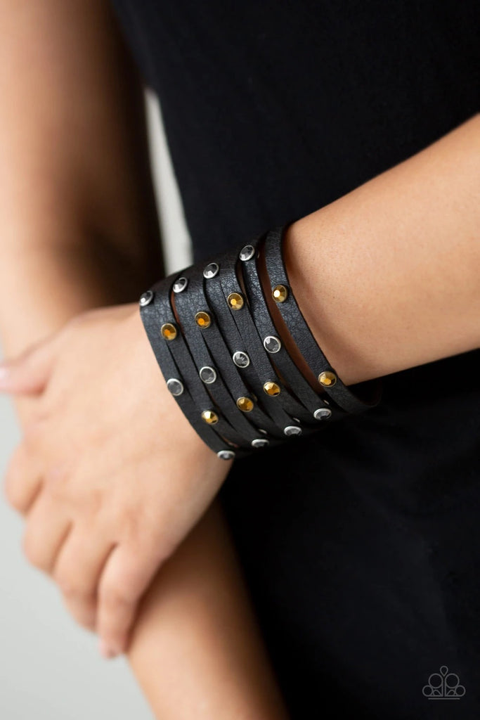 A thick black leather band has been spliced into eight strips across the wrist. Encased in sleek silver fittings, glittery hematite and aurum rhinestones are sprinkled across the center for a sassy finish. Features an adjustable snap closure.  Sold as one individual bracelet.