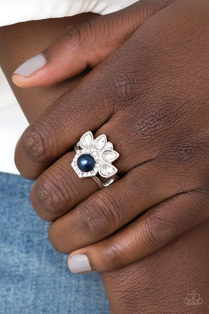 Featuring regal teardrop cuts, glittery white rhinestones flare from the center of a blue pearl drop center. Dainty white rhinestones spin around the pearly center for a glamorous finish. Features a stretchy band for a flexible fit.  Sold as one individual ring.