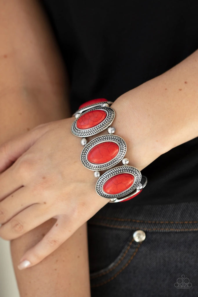 Separated by pairs of silver beads, red stone dotted rustic silver frames are threaded along stretchy bands around the wrist for a seasonal flair.  Sold as one individual bracelet.