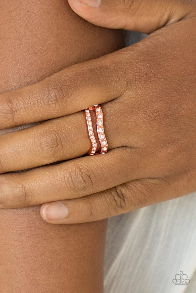 Varying in size, glittery white rhinestones are encrusted along waving shiny copper bands for a refined look. Features a dainty stretchy band for a flexible fit.  Sold as one individual ring.