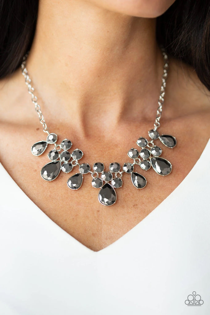 A collection of round and teardrop hematite rhinestones coalesce into dazzling frames as they link below the collar, creating a glamorous fringe. Features an adjustable clasp closure.  Sold as one individual necklace. Includes one pair of matching earrings.