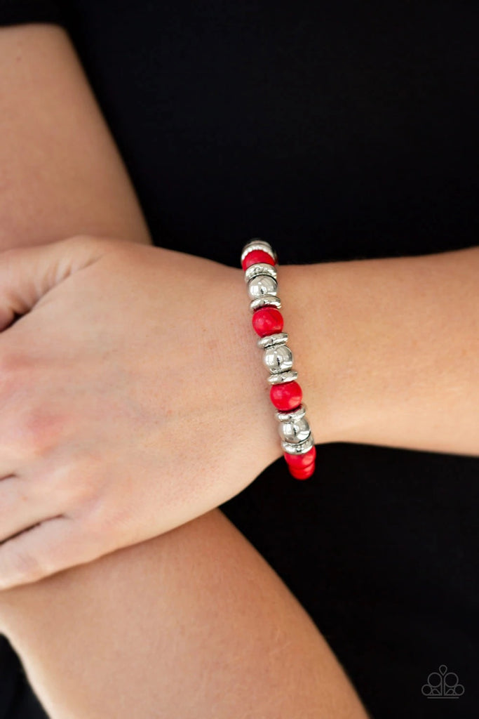 A collection of silver accents and fiery red stones are threaded along a stretchy band for a seasonal look.  Sold as one individual bracelet.