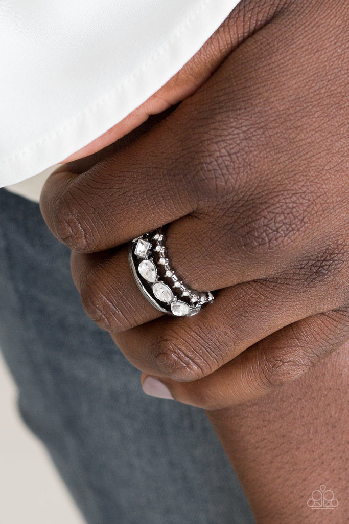 Smooth gunmetal and white rhinestone encrusted bands arc across the finger. Featuring square, teardrop, and oval style cuts, glittery white rhinestones are encrusted along the centermost band for a glamorous look. Features a stretchy band for a flexible fit.  Sold as one individual ring.