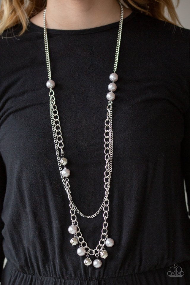 A collection of oversized gray pearls gives way to mismatched layers of silver chains down the chest for an asymmetrical look. Dotted with oversized gray pearls and shiny silver beads, a matching beaded fringe swings from the bottom of the lowermost chain for a modern twist. Features an adjustable clasp closure. Sold as one individual necklace. Includes one pair of matching earrings.