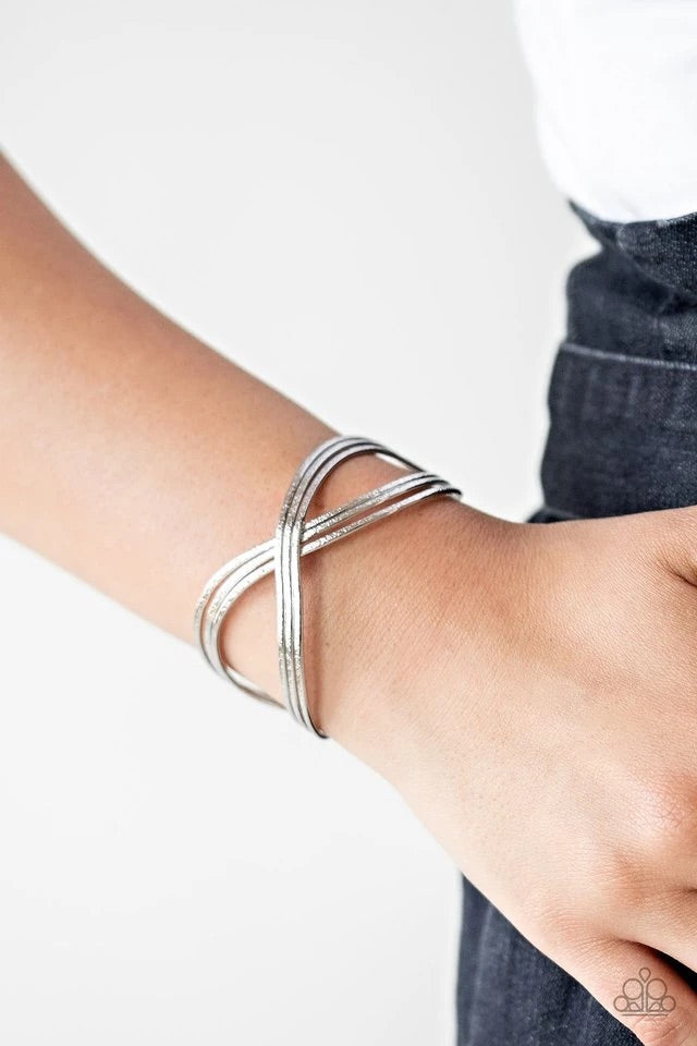 Delicately hammered in endless shimmer, shiny silver bars delicately crisscross over and around the wrist, coalescing into an infinity inspired cuff.  Sold as one individual bracelet.