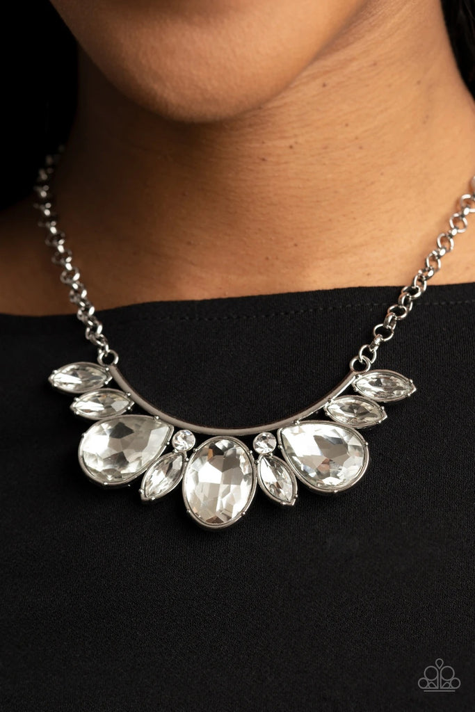 An oversized collection of round, marquise, and teardrop white rhinestones drip from the bottom of a bowing silver bar, coalescing into a sassy statement piece below the collar. Features an adjustable clasp closure.  Sold as one individual necklace. Includes one pair of matching earrings.