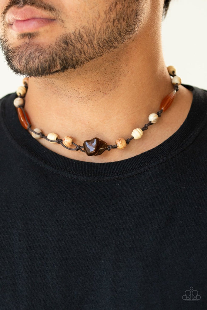 Mismatched glassy, wooden, and rock-like beads are knotted in place along strands of brown cording that loop around the neck for an island inspired look. Features a button loop closure.  Sold as one individual necklace.