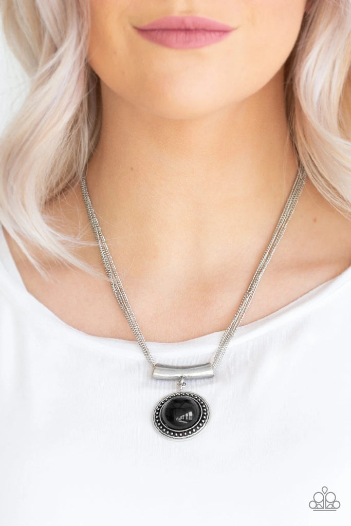 A shiny black bead is pressed into the center of a studded silver frame and attached to a shimmery silver fitting. The colorful pendant slides along four dainty silver chains below the collar for a seasonal look. Features an adjustable clasp closure.  Sold as one individual necklace. Includes one pair of matching earrings.