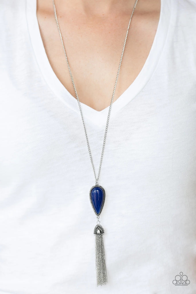 Chiseled into a tranquil teardrop, a refreshing blue stone is pressed into a decorative silver frame as it slides along a lengthened silver chain. Attached to an ornately studded silver cap, a silver chain tassel cascades from the bottom of the earthy pendant for a seasonal flair. As the stone elements in this piece are natural, some color variation is normal. Features an adjustable clasp closure.  Sold as one individual necklace. Includes one pair of matching earrings.