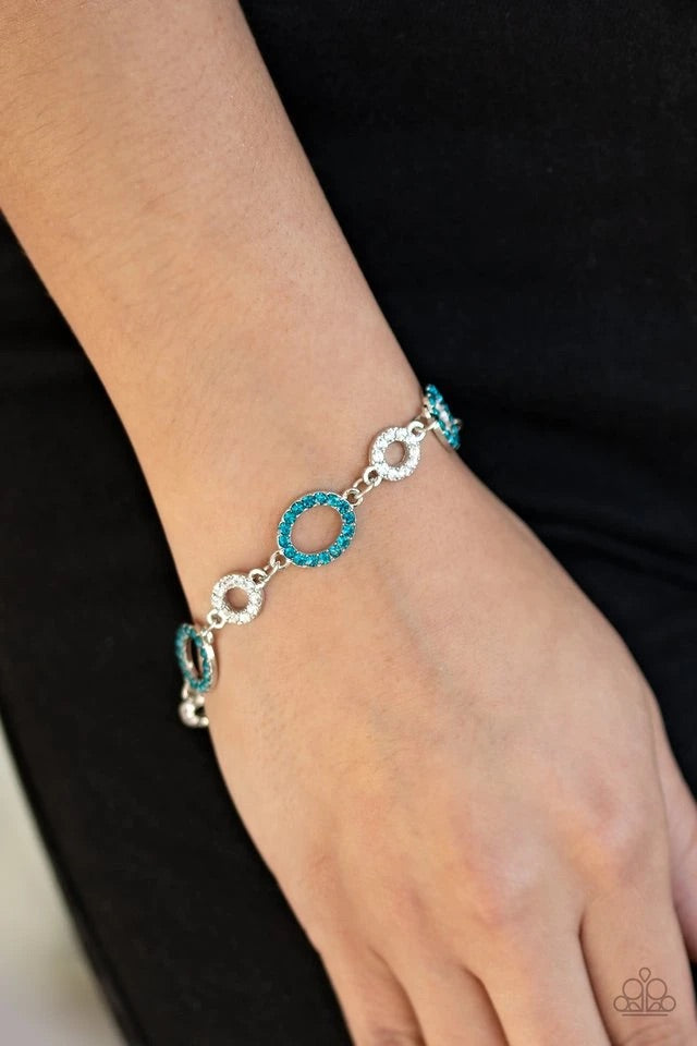 A series of blue and white rhinestone encrusted silver frames link across the wrist, creating a bubbly sparkle. Features an adjustable clasp closure. Sold as one individual bracelet.