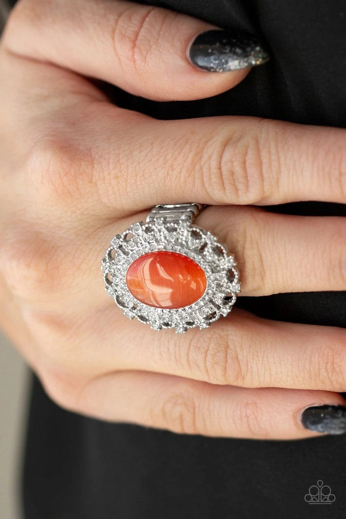 Encrusted in dainty white rhinestones, a frilly silver frame spins around a glowing orange moonstone center for a regal look. Features a stretchy band for a flexible fit.  Sold as one individual ring.