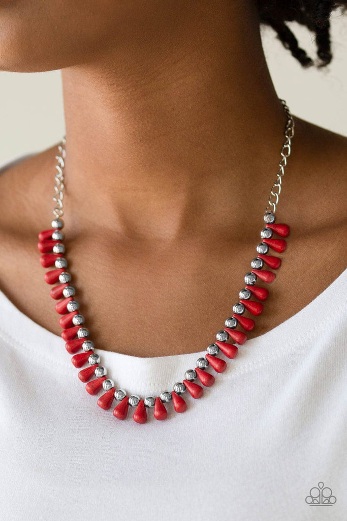 Red teardrop stones and classic silver beads are threaded along an invisible wire. The earthy beads alternate below the collar, creating a wild fringe. Features an adjustable clasp closure.  Sold as one individual necklace. Includes one pair of matching earrings.  