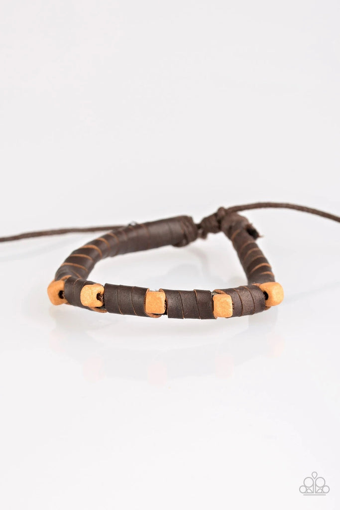 Infused with square wooden beads, brown leather cording wraps around a skinny leather band for an earthy look. Features an adjustable knot closure.  Sold as one individual bracelet.