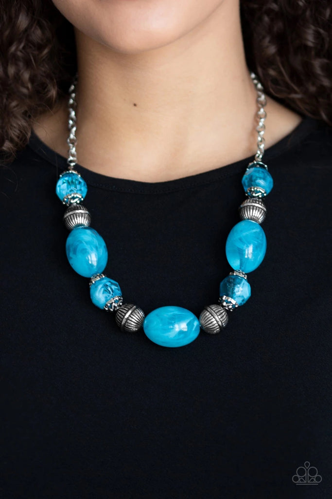 Featuring an array of antiqued silver beads, an icy collection of oversized glassy blue beads are threaded along an invisible wire below the collar for a colorful, statement making look. Features an adjustable clasp closure.  Sold as one individual necklace. Includes one pair of matching earrings.