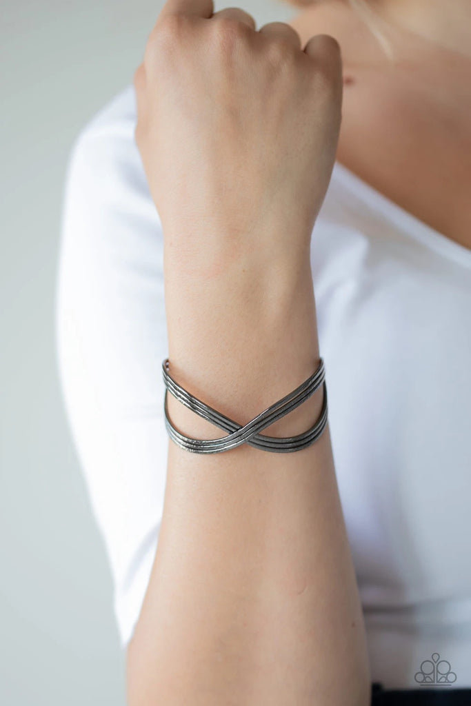 Delicately hammered in endless shimmer, shiny gunmetal bars delicately crisscross over and around the wrist, coalescing into an infinity inspired cuff.  Sold as one individual bracelet.