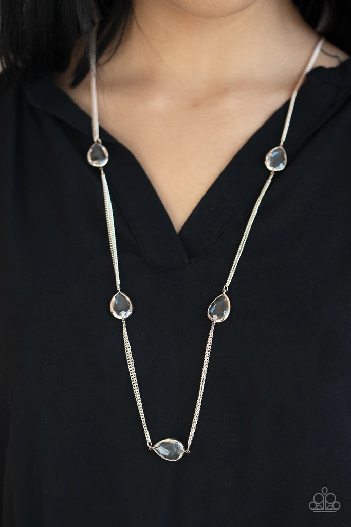 Glassy white teardrops attach to sections of rose gold chain across the chest, creating a refined display. Features an adjustable clasp closure.  Sold as one individual necklace. Includes one pair of matching earrings.  