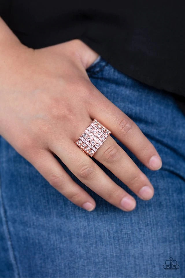 Infused with dainty studded details, rows of glassy white rhinestones stack across the front of a thick shiny copper band for an edgy fashion. Features a stretchy band for a flexible fit. Sold as one individual ring.