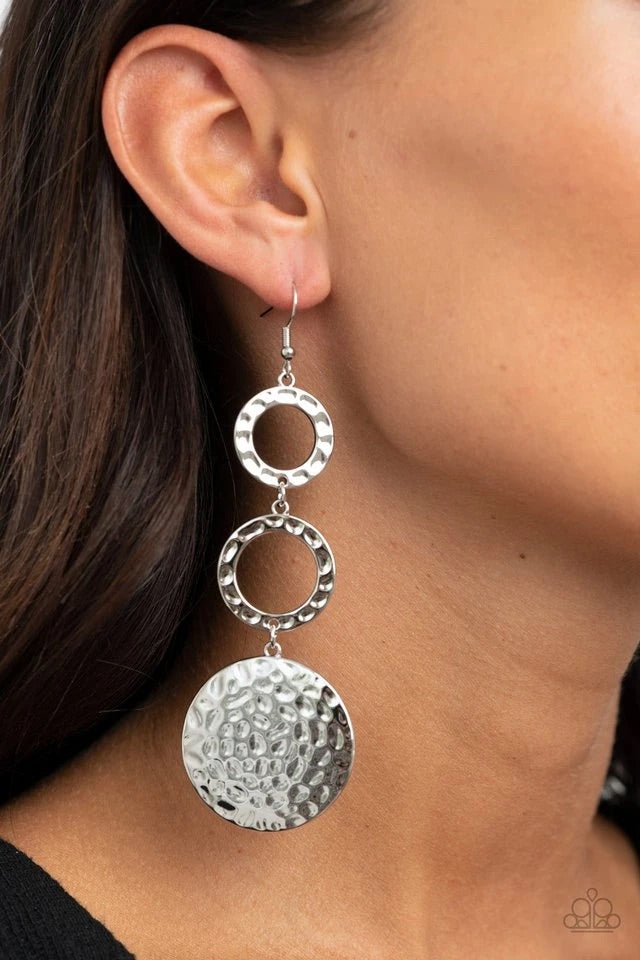 A pair of hammered silver rings gives way to an oversized hammered silver disc, creating a shimmery stacked lure. Earring attaches to a standard fishhook fitting.  Sold as one pair of earrings.