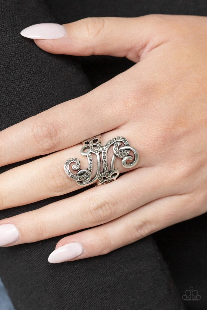 Encrusted in smoky rhinestones, a sparkling ribbon intertwines with a smooth silver ribbon, swirling into a whirl of dainty butterfly frames. Features a stretchy band for a flexible fit.  Sold as one individual ring.