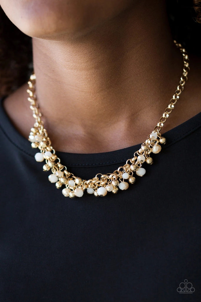 Dipped into a golden metallic shimmer, faceted white beads and classic gold beads swing from interlocking gold chains, creating a refined fringe below the collar. Features an adjustable clasp closure.  Sold as one individual necklace. Includes one pair of matching earrings.