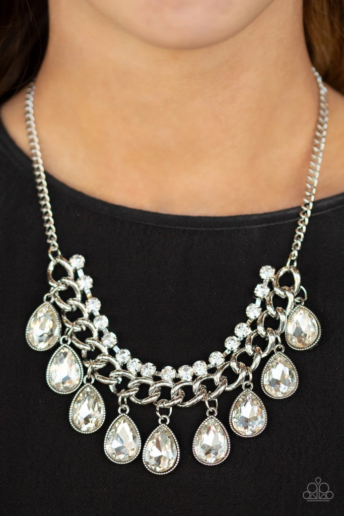 Teardrop white rhinestones swing from the bottom of a bold silver chain, creating a dramatic fringe below the collar. A strand of glittery white rhinestones attach to the top of a shimmery silver chain, adding a refined flair to the flashy statement piece. Features an adjustable clasp closure.  Sold as one individual necklace. Includes one pair of matching earrings.  