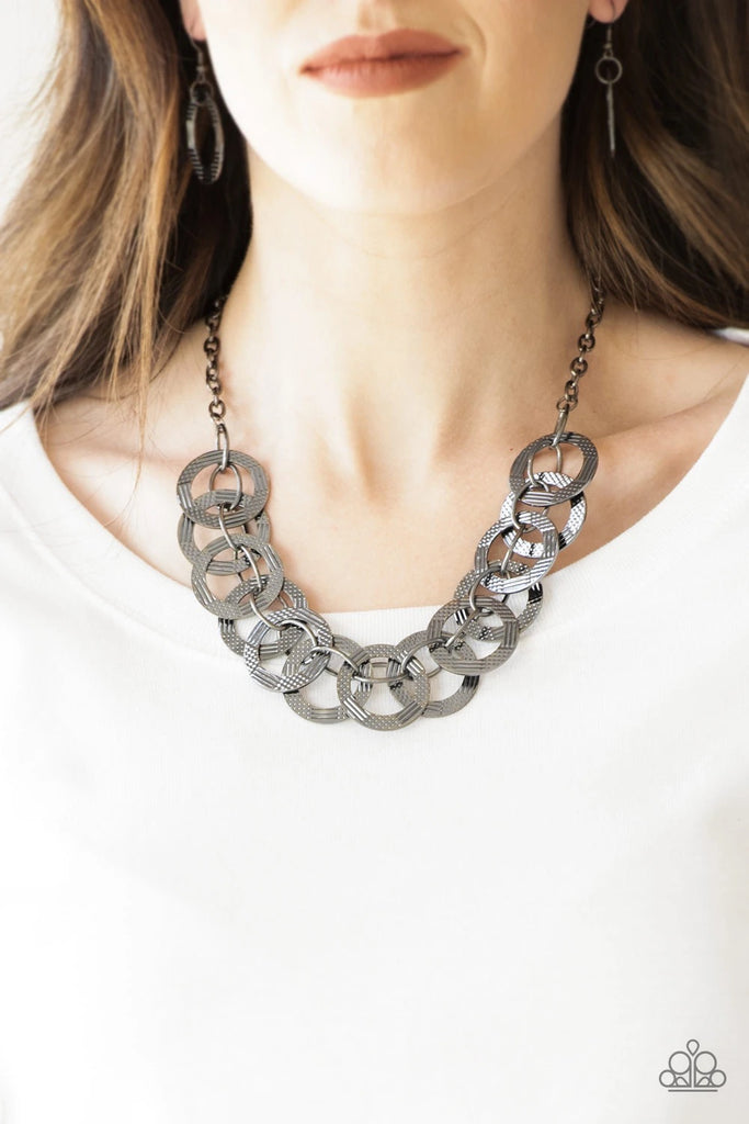 Etched and hammered in linear and diamond-cut shimmer, glistening gunmetal circles interlock into a bold industrial chain below the collar. Features an adjustable clasp closure.  Sold as one individual necklace. Includes one pair of matching earrings.