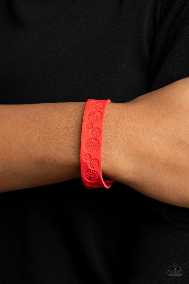 Stamped in a whimsical daisy pattern, a dainty red leather band wraps around the wrist for a seasonal flair. Features an adjustable snap closure.  Sold as one individual bracelet.