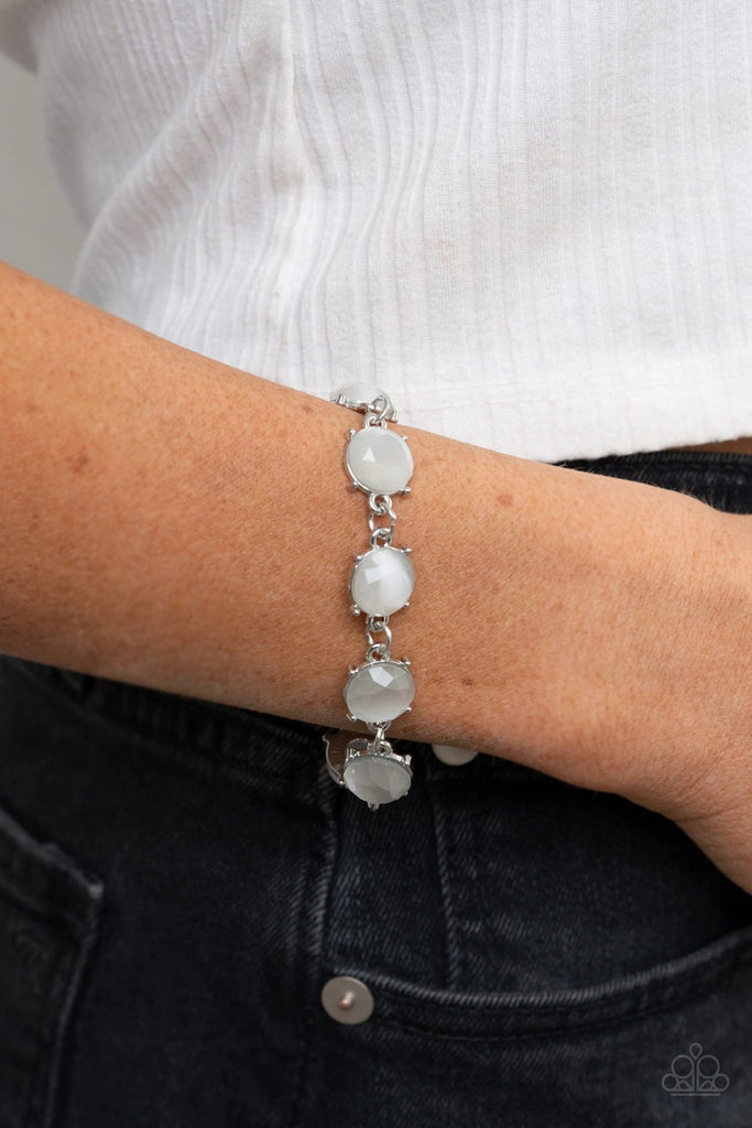 A glowing collection of faceted white cat's eye stone frames delicately connect across the wrist for an ethereal look. Features an adjustable clasp closure.  Sold as one individual bracelet.