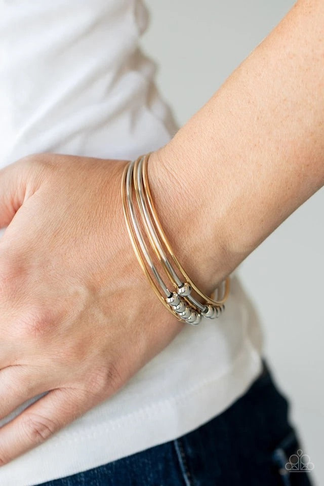 A shiny collection of plain and silver beaded gold and silver bangles slide up and down the wrist for a classically stacked look. Sold as one set of five bracelets.