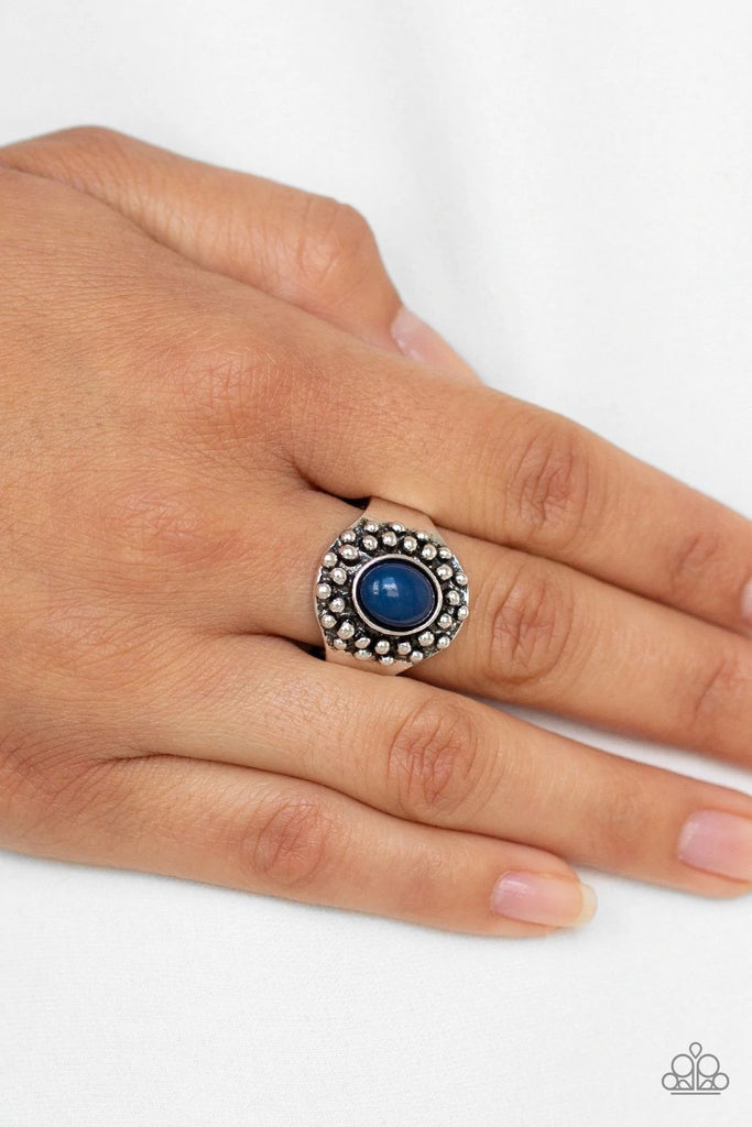 An oval blue bead is pressed into a dainty silver frame radiating with antiqued silver studs for a whimsical look. Features a dainty stretchy band for a flexible fit.  Sold as one individual ring.