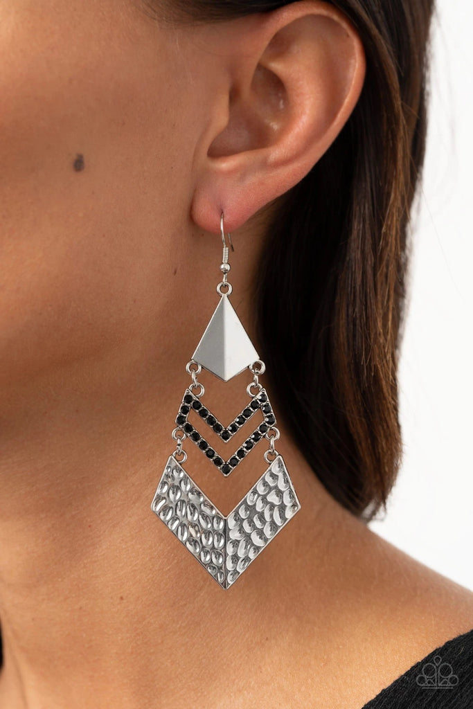 A creased silver kite-shaped frame, black rhinestone encrusted chevron-like frame, and hammered silver chevron-like frame link into an edgy lure. Earring attaches to a standard fishhook fitting.  Sold as one pair of earrings.