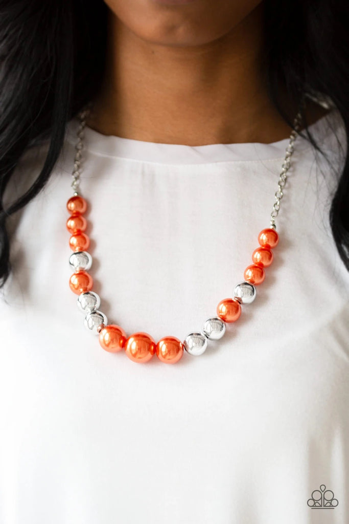 A collection of oversized silver and pearly orange beads drape across the chest for a refined look. Features an adjustable clasp closure.  Sold as one individual necklace. Includes one pair of matching earrings.