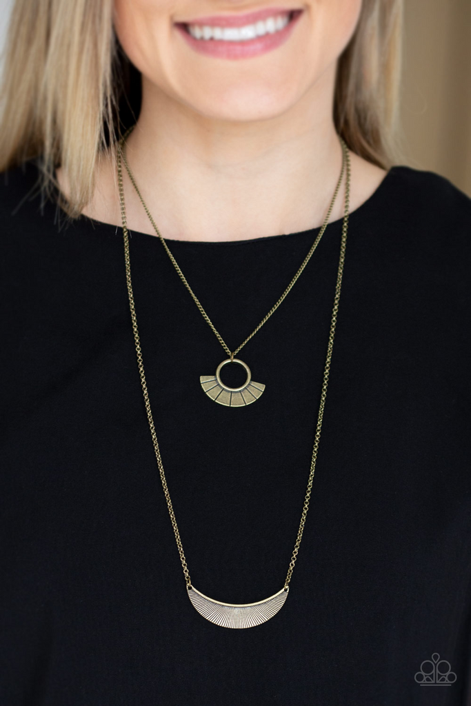 Radiating with linear patterns, a flared brass frame swings above a brass half-moon frame, creating tribal inspired layers below the collar. Features an adjustable clasp closure.  Sold as one individual necklace. Includes one pair of matching earrings.