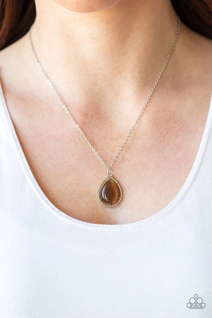 A brown teardrop stone is nestled inside a dainty golden topaz rhinestone encrusted frame, creating a glamorous pendant below the collar. Features an adjustable clasp closure.  Sold as one individual necklace. Includes one pair of matching earrings.