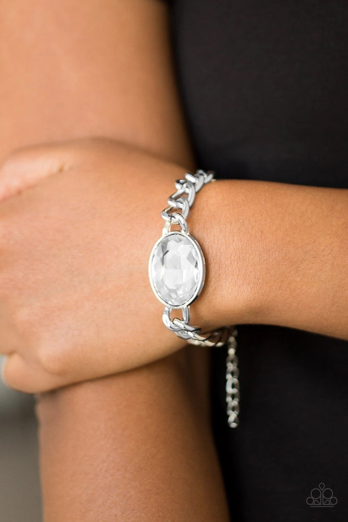 An over sized white gem attaches to a bold silver chain, creating a dramatic centerpiece atop the wrist. Features an adjustable clasp closure.  Sold as one individual bracelet.