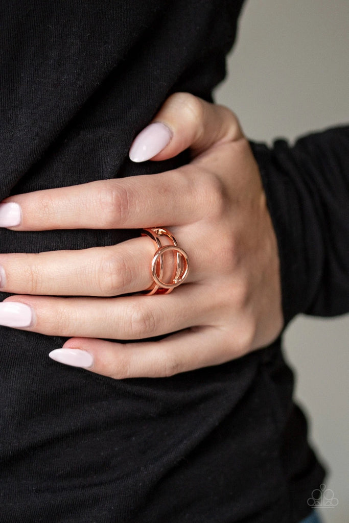 An airy shiny copper circle rests atop two arcing shiny copper bands, creating a bold minimalistic piece atop the finger. Features a dainty stretchy band for a flexible fit. Sold as one individual ring.