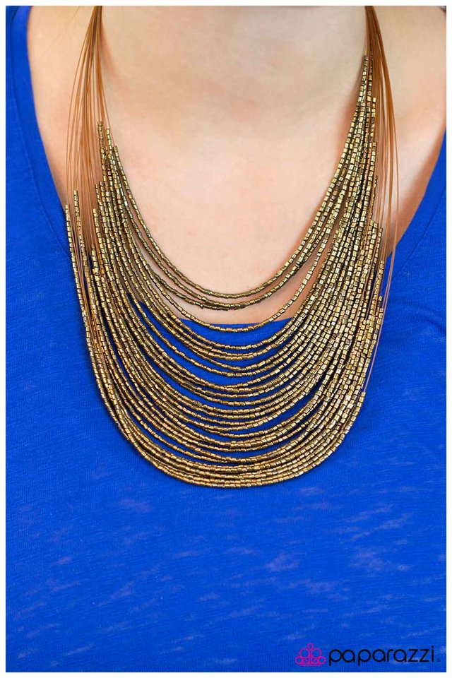 Strand after strand of shimmering brass seed beads fall together to create a bold statement piece. Features an adjustable clasp closure. Sold as one individual necklace. Includes one pair of matching earrings.