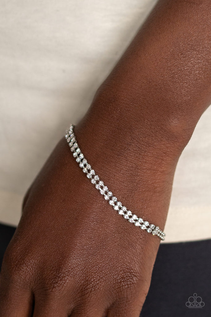 Delicately coalescing into a solitaire centerpiece, two dainty silver ball chains attach to two rows of glassy white rhinestones across the wrist for a timeless look. Features an adjustable clasp closure.  Sold as one individual bracelet.  